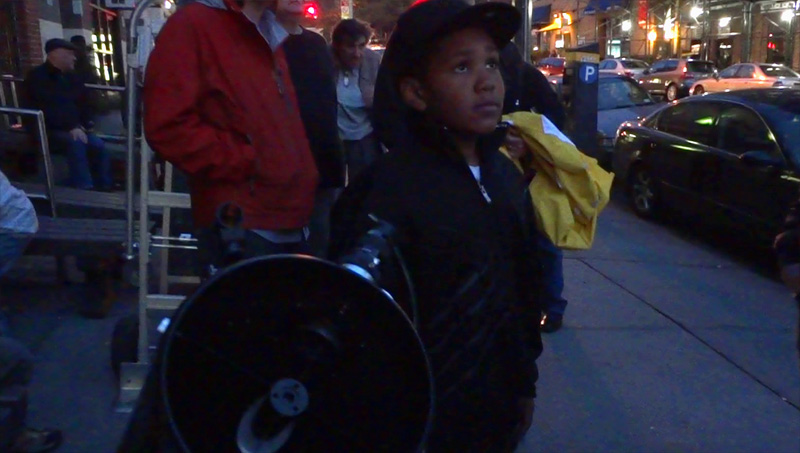 child looking through telescope